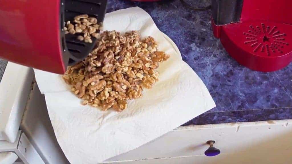 Air fryer em ação, torrando nozes uniformemente e deixando-as crocantes e saborosas.